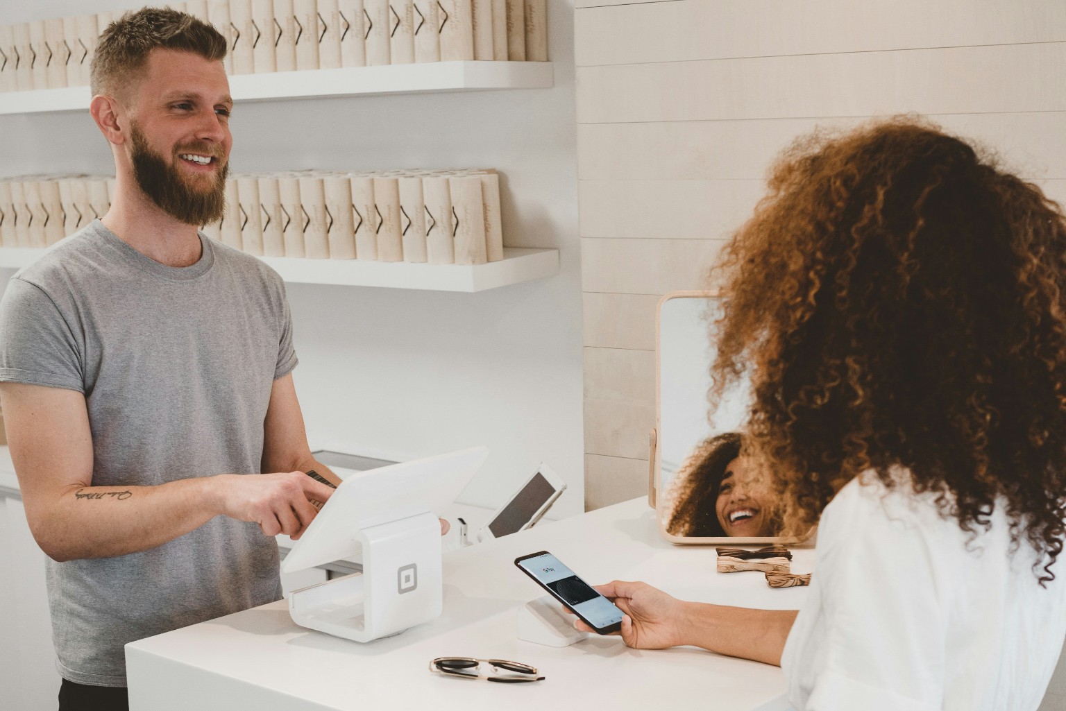 Retail employee assisting a customer paying at the counter